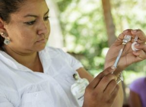 A health worker prepares a vaccine.